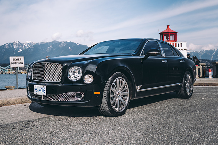 Black Bentley Mulsanne for rent with mountain and water back drop.